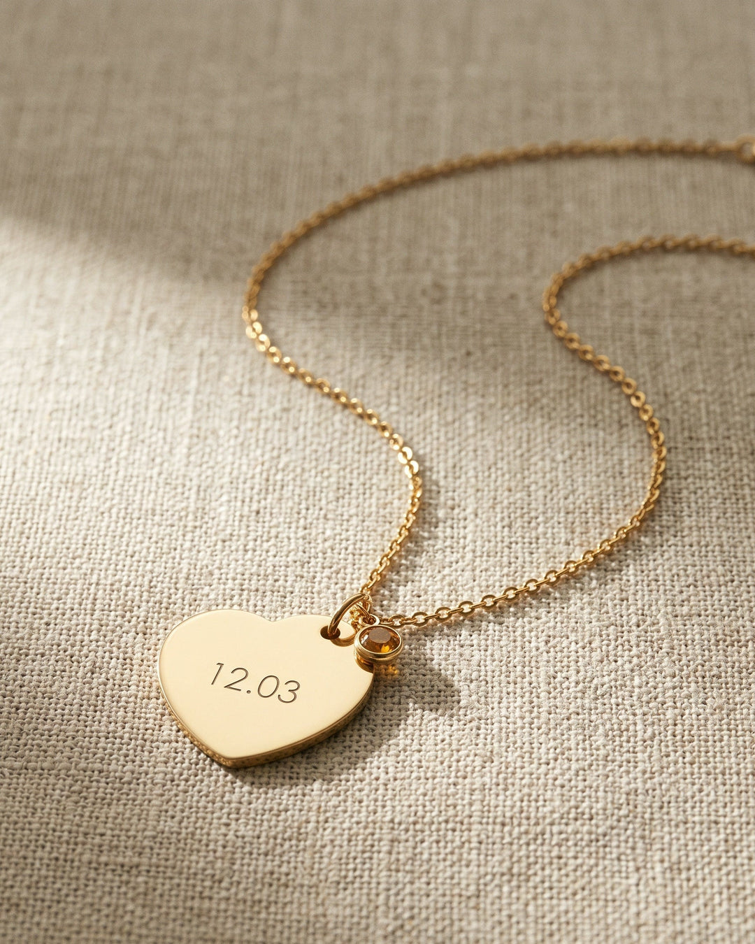 Nº 12, ketting met hart 20 bij 25 mm, goudkleurig roestvrij staal, op linnen ondergrond