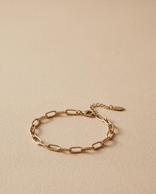 Nº 6, schakelarmband 16,5 cm, goudkleurig roestvrij staal, op zandkleurige ondergrond