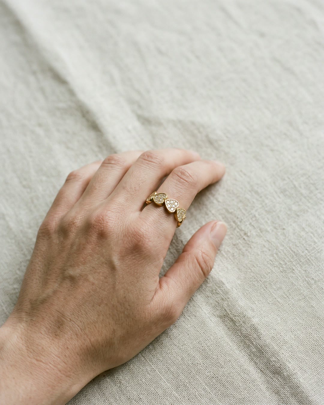 Nº 8, ring met hartjes, goudkleurig roestvrij staal, gedragen aan de hand