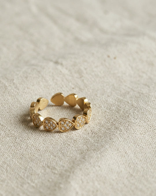 Nº 8, ring met hartjes, goudkleurig roestvrij staal, op linnen ondergrond